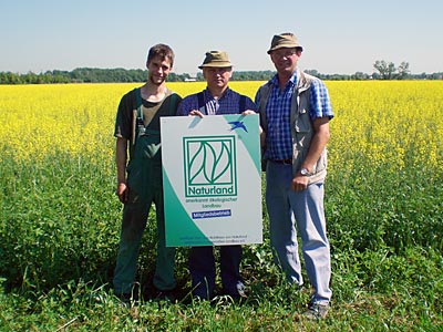 Drei Männer mit Naturland Schild